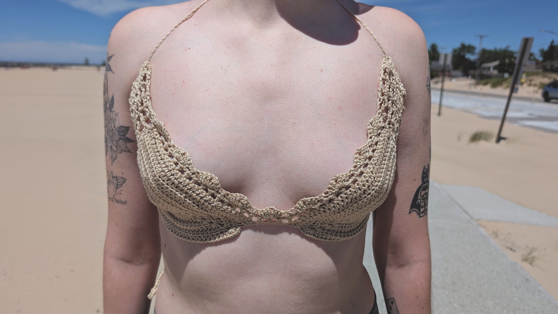 Person wearing a beige crochet bikini top in a desert setting