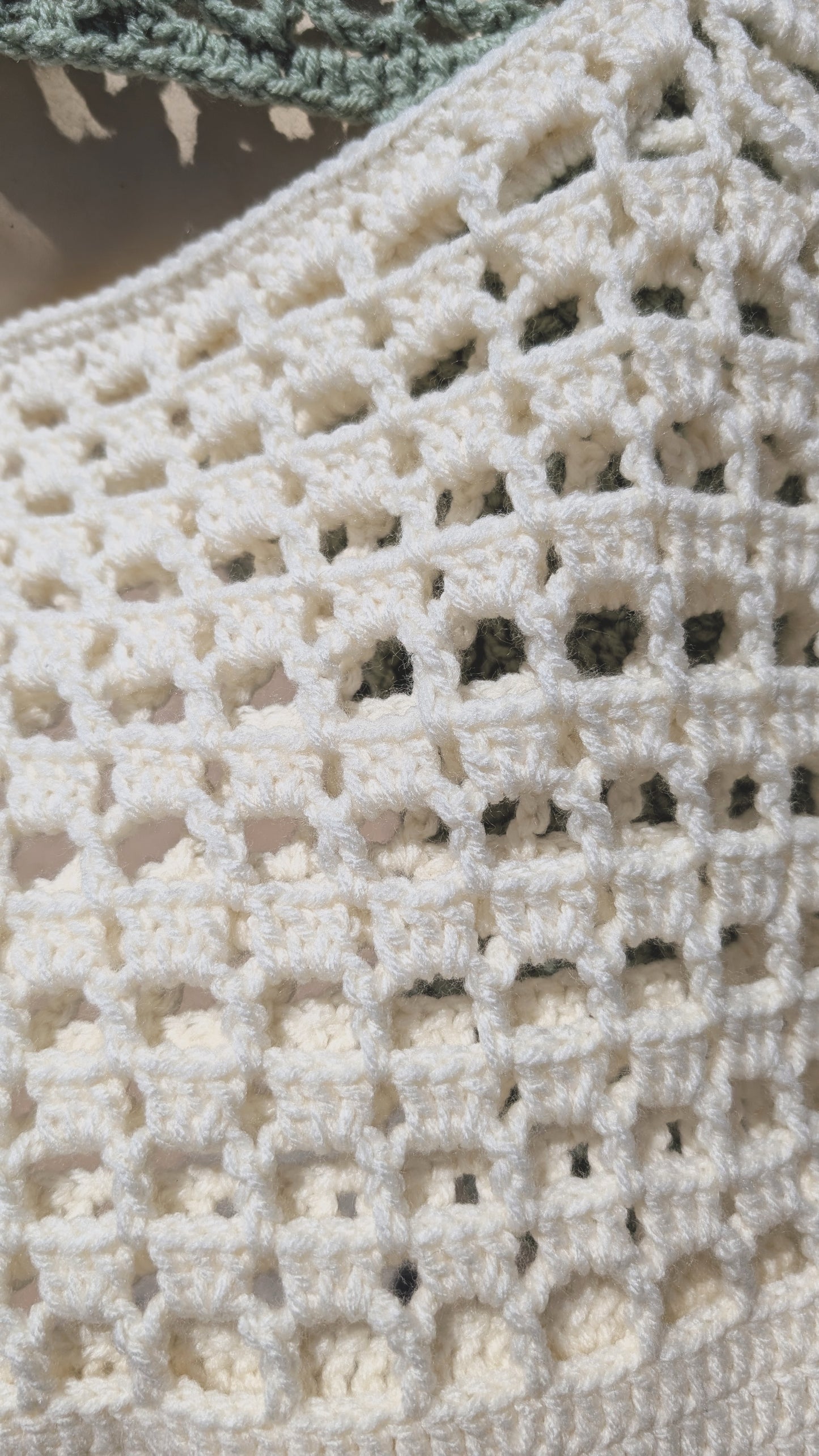 Close-up of a crocheted fabric with a textured pattern
