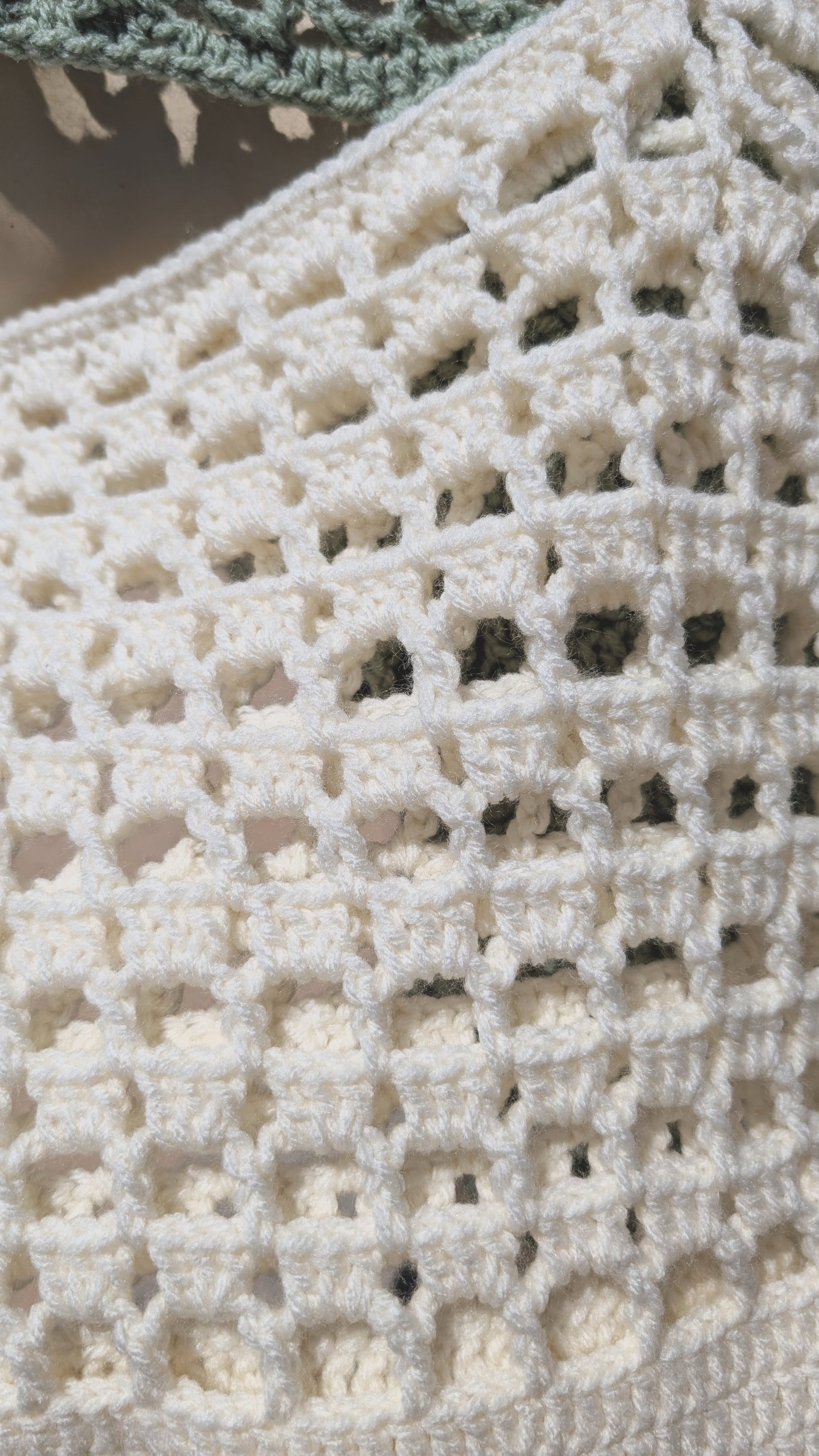 Close-up of a crocheted fabric with a textured pattern